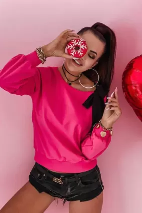 Maglia fucsia in cotone a manica lunga con fiocco nero decorativo su una spalla